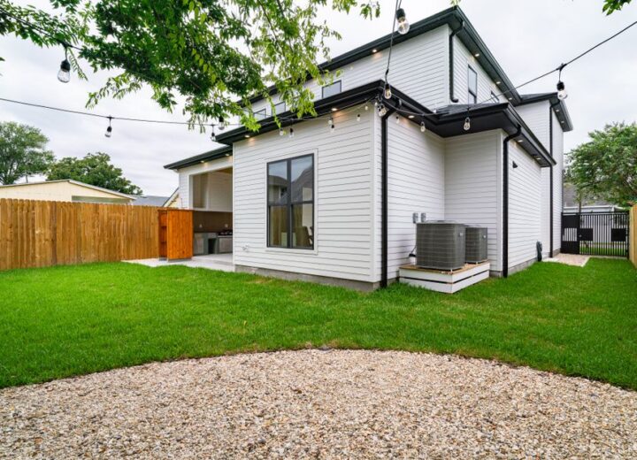 Spacious backyard view featuring a modern exterior and neat landscaping.