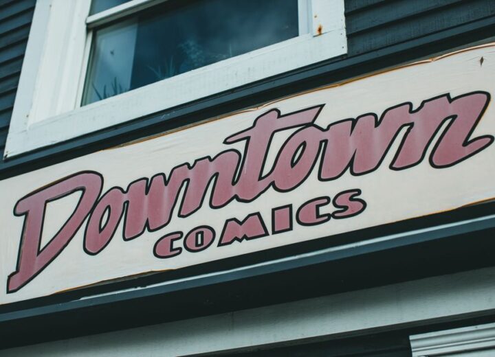 Close-up of a retro 'Downtown Comics' sign on a building facade.