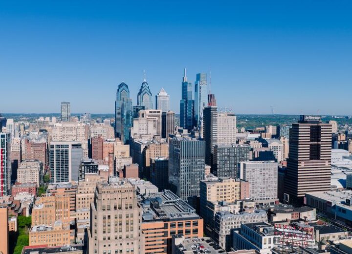 Stunning aerial view of Philadelphia's iconic skyline with modern skyscrapers under a clear blue sky.