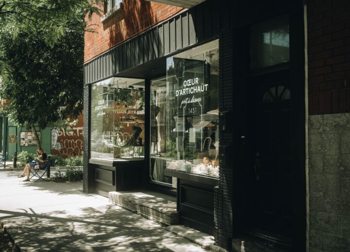 A quaint urban storefront with a glass window on a sunny summer day.