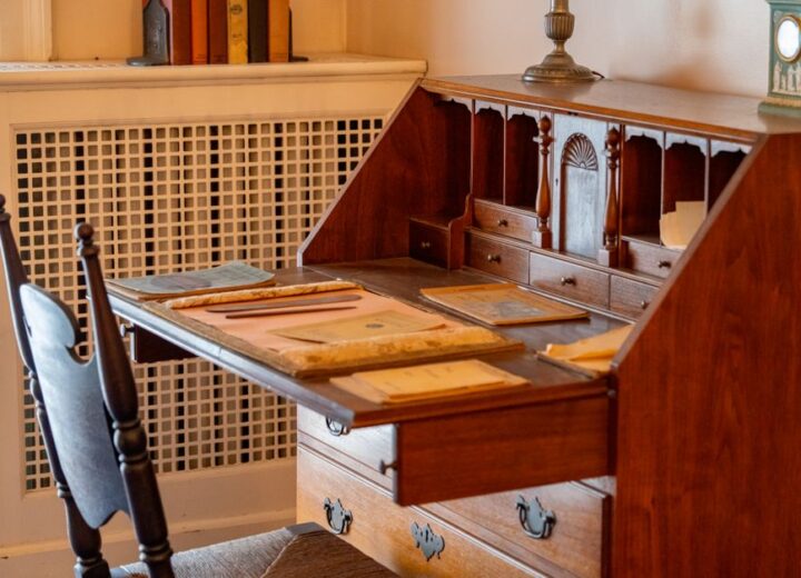 A charming wooden desk with vintage writing supplies in a cozy room.