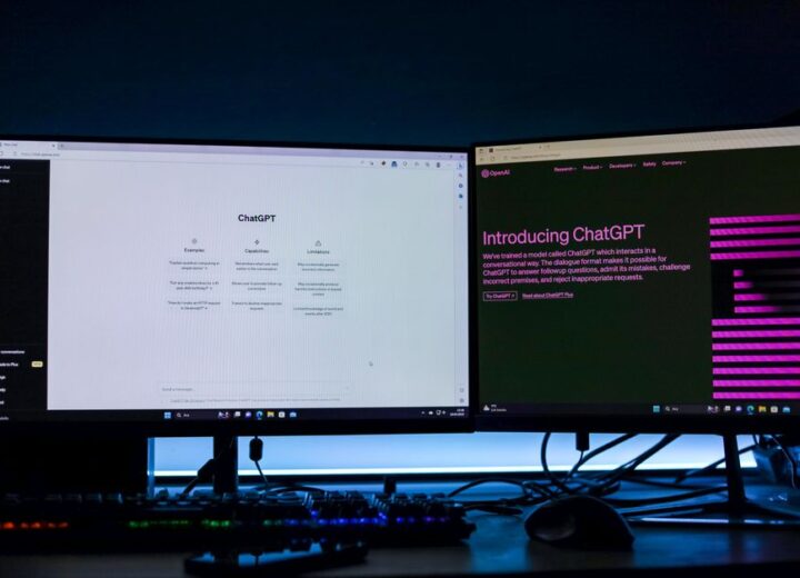 Dual computer monitors showcasing a chat interface in a technology workspace setting.