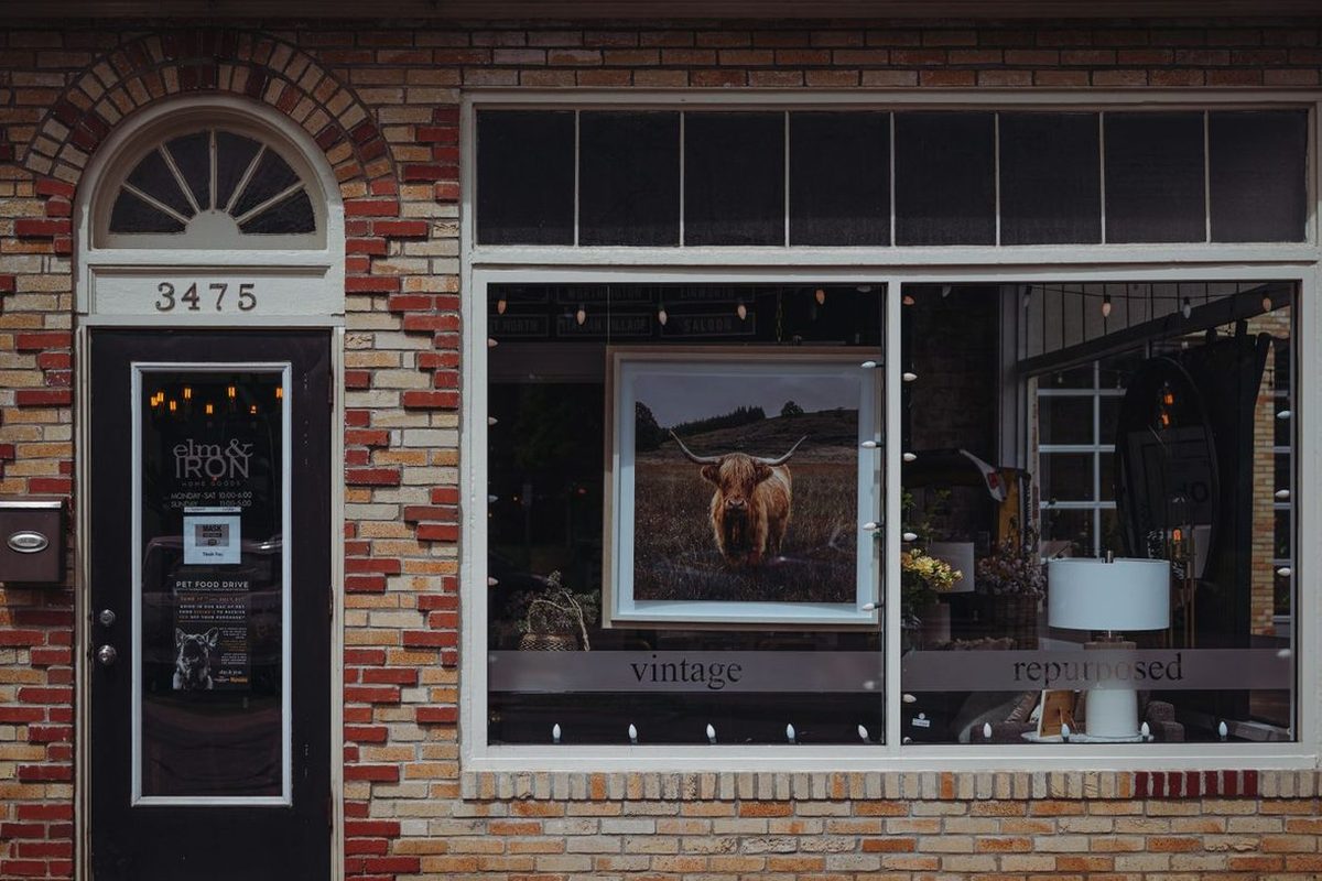 A brick storefront with a lit window display