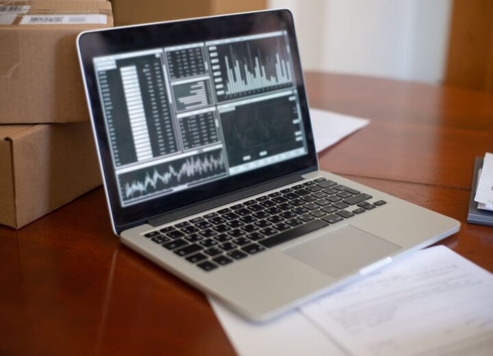 A laptop showing cost and usage charts on a small business desk