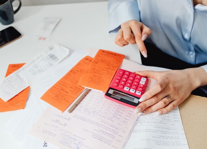 A rent ledger and bank statement being reconciled by hand