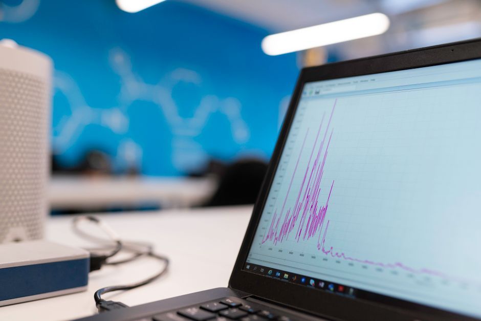 A laptop showing a measurement graph on an office desk